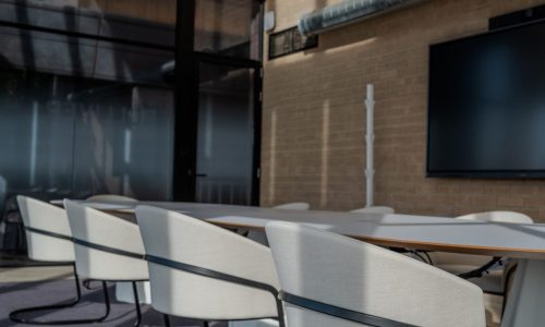 Sala de reuniones con pantalla en The Terminal Hub